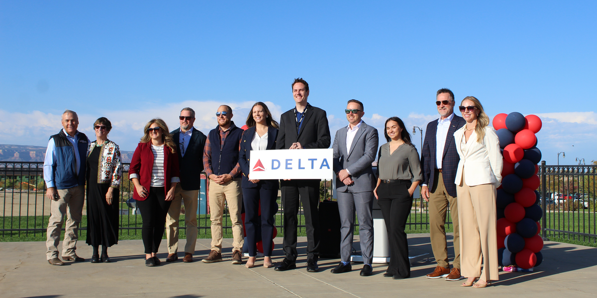 Group of airport personnel with a Delta Sign